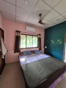een slaapkamer met een groot bed in een kamer bij anandi holidays homestay in Malvan