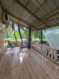 een kamer met een houten vloer en een balkon bij anandi holidays homestay in Malvan