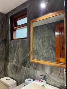 a bathroom with a sink and a mirror and a toilet at HOTEl CHAIS in Colorines