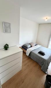 ein Schlafzimmer mit einem Bett und einer weißen Wand in der Unterkunft Paris panorama in Villemomble + 22 Fotos