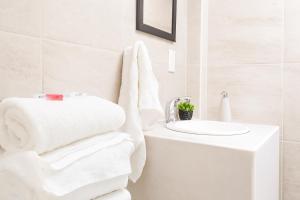 a white bathroom with a sink and towels at Hospedaje Aldana - Habitación ACUA zona centro in Tuxpan de Rodríguez Cano +1 photo