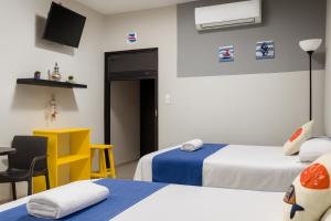 图斯潘罗德里格斯卡诺Hospedaje Aldana - Habitación ACUA zona centro的有两张床、一张桌子和一张椅子的房间