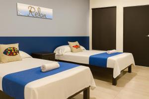 图斯潘罗德里格斯卡诺Hospedaje Aldana - Habitación ACUA zona centro的蓝白相间的房间里有两张床