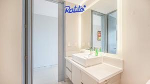 une salle de bains avec un lavabo blanc et un miroir dans l'établissement 3A Torre KU 2BR Sofa DowntownView PrivateBalcony, à Puerto Vallarta