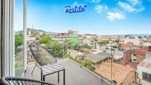 une chaise sur un balcon avec vue sur une ville dans l'établissement 3A Torre KU 2BR Sofa DowntownView PrivateBalcony, à Puerto Vallarta