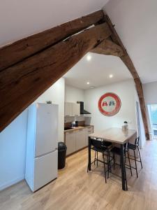 una cucina con un tavolo e un frigorifero bianco di Séjour authentique aux portes de la Sologne a Vierzon