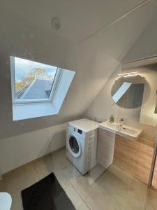 un bagno con lavatrice e lavandino di Séjour authentique aux portes de la Sologne a Vierzon