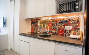Una cocina con fregadero y pared de azulejos. en Studio Pop Art, en Batajnica 2 fotos más