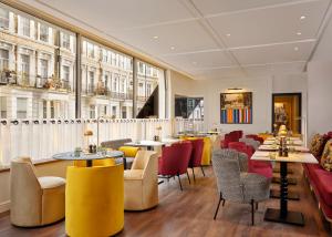 伦敦The Cura Hotel Kensington, London, a Tribute Portfolio Hotel的一家有桌椅和窗户的餐厅 更多18张照片