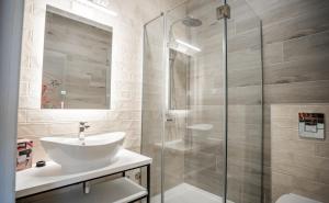 Un baño con lavabo y ducha de cristal. en Studio Pop Art, en Batajnica