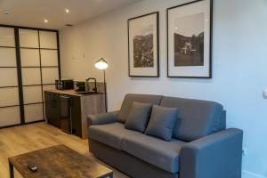 a living room with a blue couch and a table at La Borda del Gato Rafa in Vielha