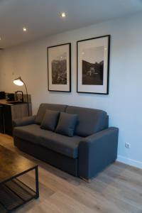 a blue couch in a living room with two pictures on the wall at La Borda del Gato Rafa in Vielha +49 photos