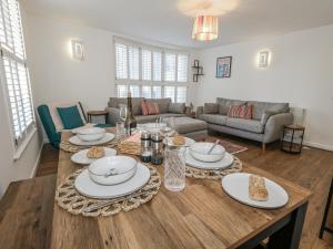 a living room with a table with plates of food on it at Betty's Buoy in Weymouth