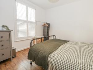 a bedroom with a bed and a dresser and a window at Betty's Buoy in Weymouth