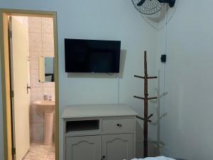 uma casa de banho com uma televisão na parede e um lavatório em Vila Marias em Ouro Preto mais 32 fotografias