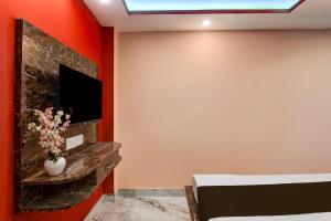 a bedroom with a wall with a fireplace and a tv at Hotel O Prasad Inn in Ballygunge +21 photos
