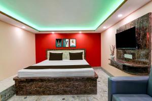 a bedroom with a bed and a red wall at Hotel O Prasad Inn in Ballygunge