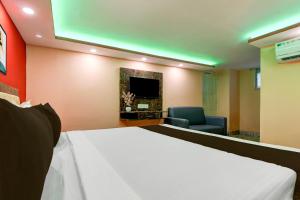 a hotel room with a bed and a tv at Hotel O Prasad Inn in Ballygunge