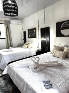 two beds in a room with white walls at Chinuk Boutique Hotel in Puerto Viejo