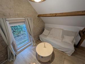 Una pequeña habitación con una cama y una ventana. en Jo And Manu's Barn, en Falaise