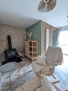 una sala de estar con un sofá y una silla en Jo And Manu's Barn, en Falaise