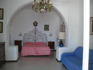 a bedroom with a red bed and a chandelier at Casa Athena in Lipari