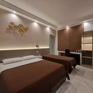 una camera d'albergo con due letti e una scrivania di B&B Sol Romae a Roma Altre 22 foto