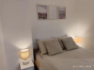 a bedroom with a bed with two lamps on it at PortStreet apartamenti in Liepāja