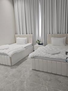 due letti uno accanto all'altro in una stanza di فلة الشروق - Sunrise Villa a Sur
