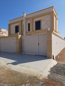 ein Haus mit einer Garage mit Auffahrt in der Unterkunft فلة الشروق - Sunrise Villa in Sur