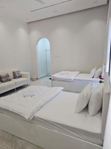 una stanza con due letti e un divano di فلة الشروق - Sunrise Villa a Sur Altre 11 foto