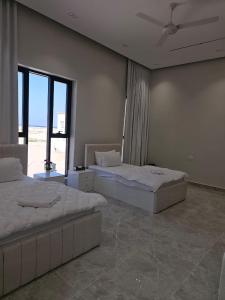 2 letti in una grande stanza con finestra di فلة الشروق - Sunrise Villa a Sur