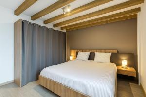 Saint-Maurice-lʼExilHome的卧室里有一张白色的床，上面有两个枕头