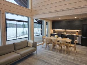 ein Wohnzimmer mit Couch und Tisch und eine Küche in der Unterkunft Villa Taipale - 8hlö, Himosranta in Jämsä + 19 Fotos