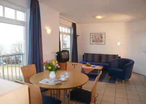 ein Wohnzimmer mit Tisch und Stühlen und einer Couch in der Unterkunft Ferienwohnungen in der Villa Regina Maris in Bansin