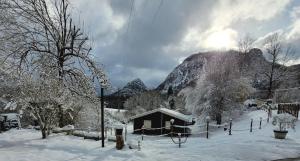 SauratLES CHALETS de MONTORGUEIL的雪中小屋,山底下