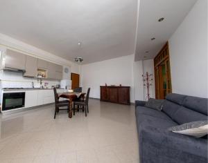 un soggiorno con un divano blu e un tavolo di Marisella holidays house a Pozzuoli