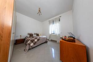 a bedroom with a bed in a white room at Marisella holidays house in Pozzuoli