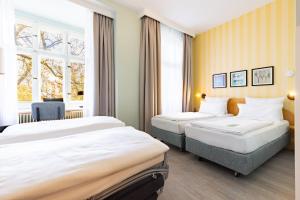 ein Hotelzimmer mit zwei Betten und einem Fenster in der Unterkunft Garner Hotel Berlin - Messe by IHG in Berlin + 150 Fotos