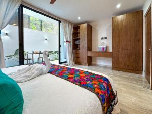 a bedroom with a bed with a colorful blanket on it at Casa Daniela in Puerto Morelos +39 photos