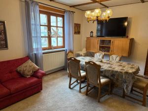 a living room with a table and a red couch at Harzhaus in Schierke in Schierke