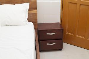 a bed with a night stand next to a bed with a pillow at Royal prima guest house, apartment and event center in Amanfro