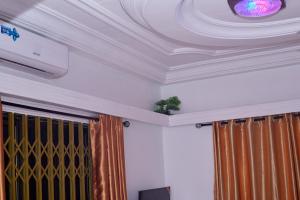 a room with a white coffered ceiling and curtains at Royal prima guest house, apartment and event center in Amanfro
