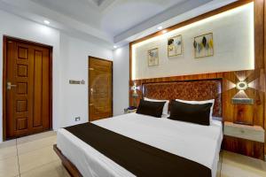 una camera da letto con un letto grande con testiera in legno di Townhouse Cochin Airport Formerly Skyluxe a Nedumbassery
