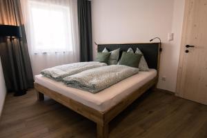 a bedroom with a bed with green pillows at ReiWaSchHOF in Dobersberg +12 photos