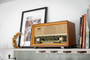 an old radio sitting on a shelf with books at ReiWaSchHOF in Dobersberg
