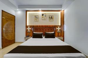una camera da letto con un letto grande con testiera in legno di Townhouse Cochin Airport Formerly Skyluxe a Nedumbassery