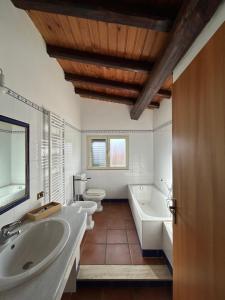 bagno con 2 lavandini, vasca e 2 servizi igienici di Otium54 apartment a Ragalna