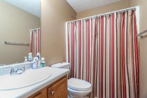 ein Badezimmer mit Toilette und Duschvorhang in der Unterkunft Sleeps 16! • 6BR • Bedroom TVs • Peaceful Suburb in Locust Grove + 23 Fotos