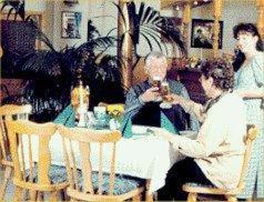 two men sitting at a table drinking wine at Gasthaus & Hotel Zur Linde in Friedrichroda